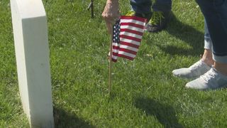  Volunteers place flags on service members’ graves for Memorial Day