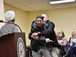 Rep. Ilhan Omar rushed on stage and sprayed with liquid at town hall event